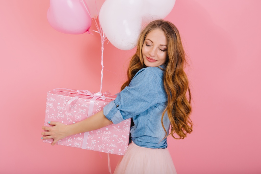 close-up-portrait-of-graceful-curly-girl-with-lovely-face-holding-present-and-balloons-for-friend-s-birthday-charming-long-haired-young-woman-with-eyes-closed-in-stylish-attire-received-gift-at-party.jpg